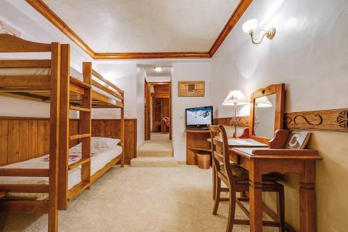 a bedroom with bunk beds and a desk with a computer at Hôtel les Campanules by Les Etincelles in Tignes