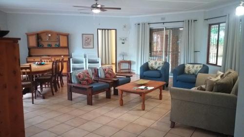 a living room with a couch and chairs and a table at 6 Fish Eagles in St Lucia