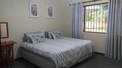 Un dormitorio con una cama con sábanas azules y blancas y una ventana. en Hooked on 6 Fish Eagles, en St Lucia