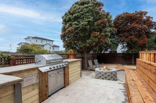 a backyard with an outdoor kitchen with a stove at Beach Unit wPrivate Hot Tub Fire Pit BBQ Walk 2 Food & Activities in Half Moon Bay