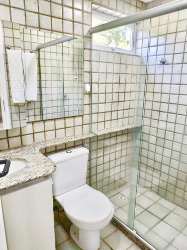 a bathroom with a toilet and a glass shower at Gavoa Resort - 2 quartos - BL D apt 209 in Igarassu