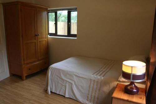 1 dormitorio con cama y ventana en The Nook - Farm Park Stay with Hot Tub & Dome, en Swansea