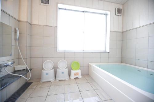 a bathroom with a toilet, tub, and sink at Kuretake Inn Gotemba Inter Gold Cabin in Gotemba