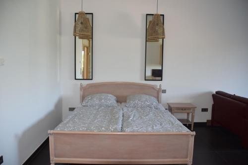 a bed in a bedroom with two mirrors on the wall at The Old Gemeinde House by the Mosel River in Brauneberg