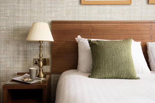 a hotel room with a bed with a lamp on a table at The Black Swan - The Inn Collection Group in Helmsley