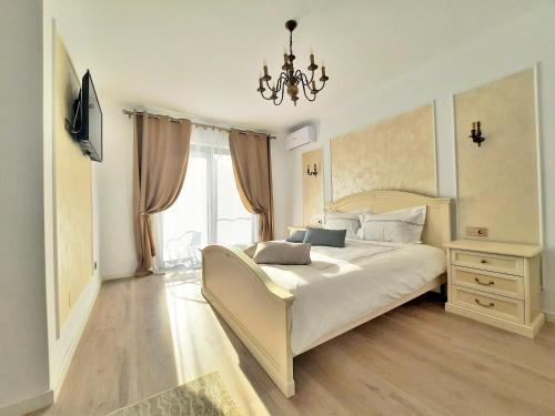 een slaapkamer met een groot wit bed en een kroonluchter bij Casa Mora in Deva