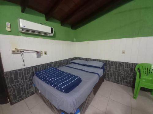 um quarto com uma cama e uma parede verde em HERMOSO APARTAMENTO MONOAMBIENTE ZONA SHOPPING em Colonia Mariano Roque Alonso