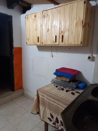 a kitchen with a table and wooden cabinets at HERMOSO APARTAMENTO MONOAMBIENTE ZONA SHOPPING in Colonia Mariano Roque Alonso