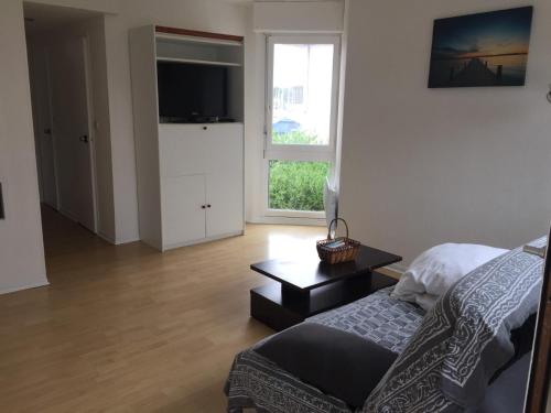 a living room with a couch and a tv at Studio Cap Sud Capbreton proche plage in Capbreton