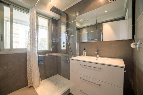 une salle de bain avec un lavabo et une douche dans l'établissement Le Prado Parc, à Cannes