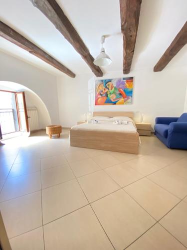 ein großes Schlafzimmer mit einem Bett und einem blauen Sofa in der Unterkunft ChSuite & PrivateParking - Corso 18 Agosto - Apartment in Potenza
