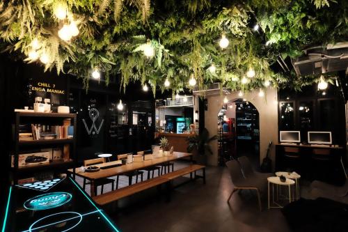 a restaurant with tables and chairs and lights at Wayha Hostel Don Mueang Airport in Bangkok