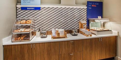 a bakery counter with donuts on display in a store at Holiday Inn Express & Suites Palm Desert - Millennium by IHG in Palm Desert