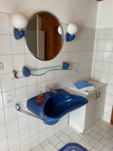 La salle de bains est pourvue d'un lavabo bleu et d'un miroir. dans l'établissement Bergmannsruh, à Clausthal-Zellerfeld