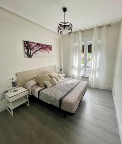 - une chambre avec un lit et une table avec une lampe dans l'établissement Apartamento Buenavista, à Oviedo