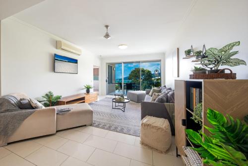 a living room with a couch and some plants at Tulip Oak in Airlie Beach
