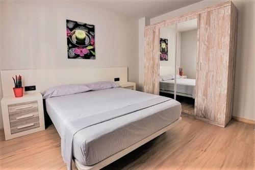 ein Schlafzimmer mit einem großen Bett und einem Spiegel in der Unterkunft APTMUNDO BAJAMAR - Precioso apartamento Planta baja y patio in Puerto de Sagunto