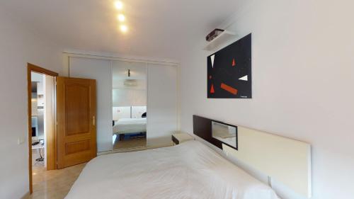 1 dormitorio con cama blanca y espejo en Tropical Paradise, en Playa del Inglés