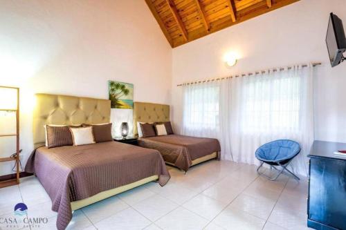 una camera d'albergo con due letti e una televisione di Luxury Villa Casa De Campo a La Romana