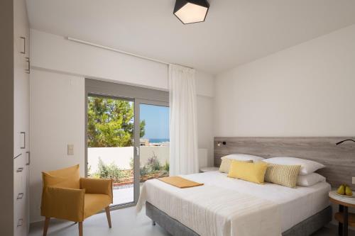 een witte slaapkamer met een groot bed en een raam bij Kallithea Residence in Rethimnon