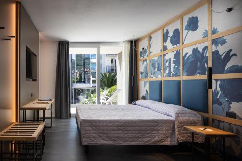 Aris Apartments & Sky Pool - TonelliHotels في ريفا ديل غاردا: غرفة نوم بسرير ونافذة