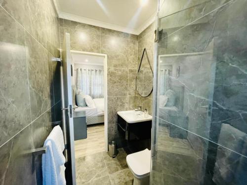 W łazience znajduje się prysznic, umywalka i toaleta. w obiekcie Cozier Glitz w Kapsztadzie
