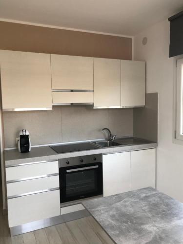 a kitchen with white cabinets and a sink at Casa Giulia in Niscemi