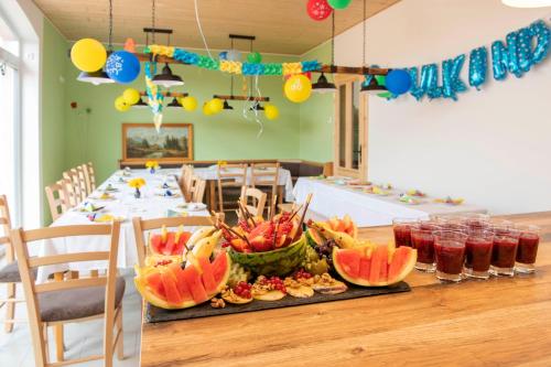 - une table avec des fruits et des boissons dans l'établissement Pension Biohof Klügel, à Freital