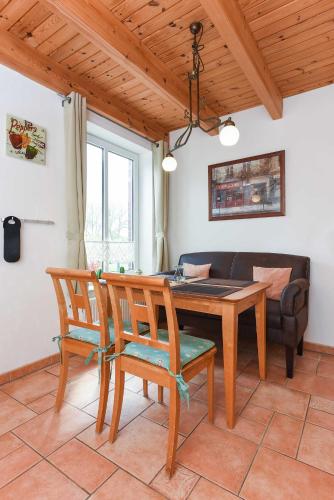 a dining room with a table and chairs and a couch at Ferienwohnungen im Haus Nordlichter in Holtgast