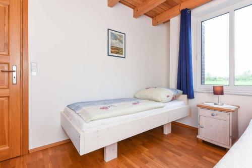 a bedroom with a bed and a window at Ferienwohnungen im Haus Nordlichter in Holtgast