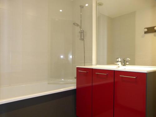 La salle de bains est pourvue d'une armoire rouge avec un lavabo et une douche. dans l'établissement travelski home select - Vue Mont Blanc, à Aime La Plagne