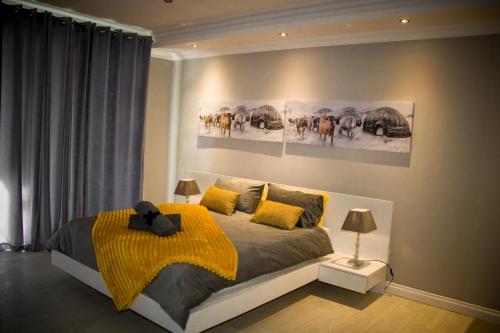 a bedroom with a bed with a yellow blanket at The Penthouse in Walvis Bay