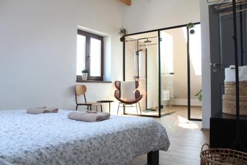 1 dormitorio con 1 cama y 2 sillas en Kafe v obýváku en Bítov