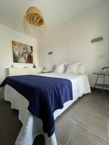a bedroom with a bed with a blue blanket on it at Casa del Castillo in El Cotillo