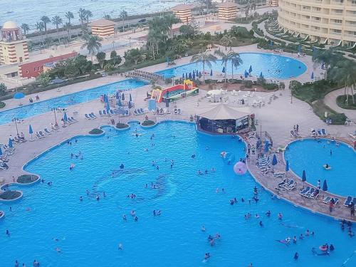 ein großer Pool in einem Resort mit Menschen darin in der Unterkunft Chalets in Porto Sokhna Pyramids in Ain Suchna