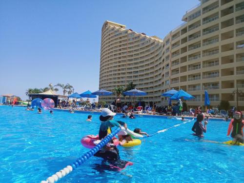 a group of people in the water at a swimming pool at Chalets in Porto Sokhna Pyramids in Ain Sokhna