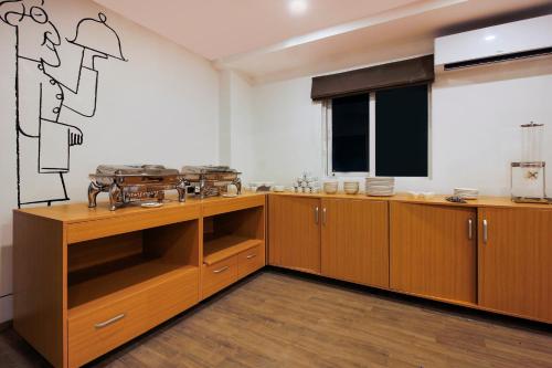 a kitchen with wooden cabinets and a large window at Super Townhouse RCC Elite in Hyderabad