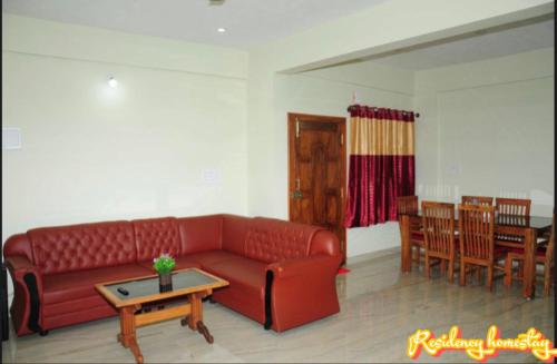 salon z czerwoną kanapą i stołem w obiekcie Coorg Residency home stay w mieście Kushalanagar