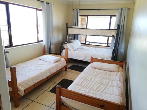 two bunk beds in a room with two windows at Surf and Sand - Fish Eagle in Ramsgate