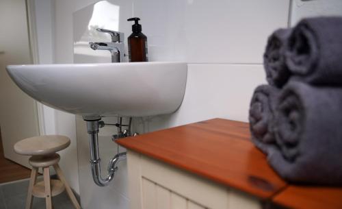a bathroom with a white sink and a stool at Altstadt Fereienwohnung Hameln in Hameln