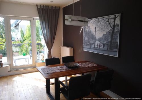 comedor con mesa, sillas y ventana en Apartment Troisdorf - Bonn en Troisdorf