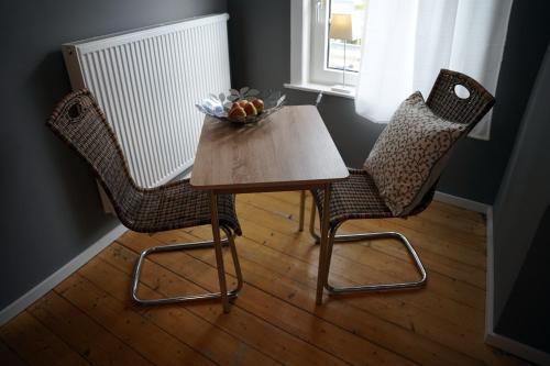 two chairs and a table with a bowl of fruit on it at Altstadt Fereienwohnung Hameln in Hameln