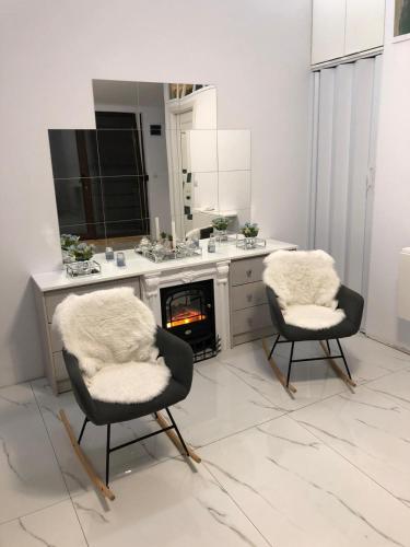 a kitchen with two chairs and a fireplace at Duplex Marquis in Braşov