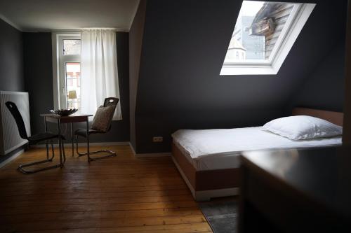 a bedroom with a bed and a table and a window at Altstadt Fereienwohnung Hameln in Hameln