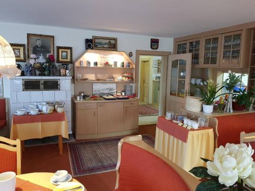 una cucina e una sala da pranzo con tavoli e sedie di Pension Seeblick a Seebruck