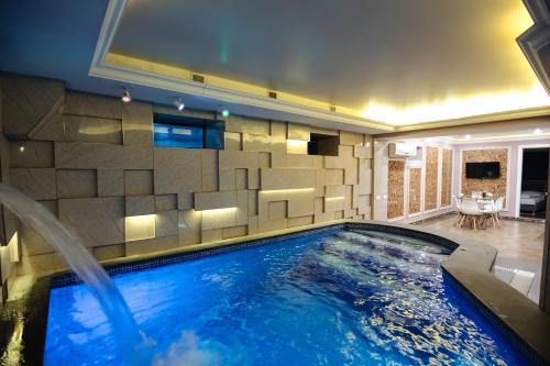 una piscina en una habitación con una pared de azulejos en GOLDEN SECONDS Hotel en Ereván