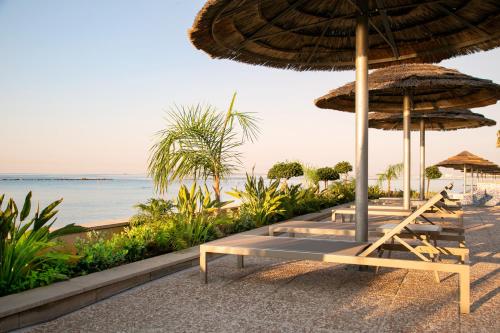 a group of chairs under an umbrella on the beach at Atlantica Miramare Beach in Limassol