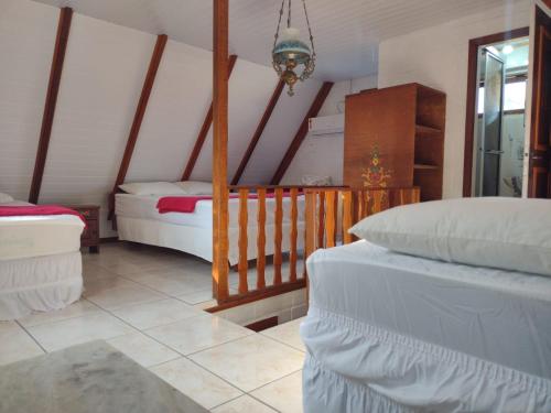 a bedroom with two beds and a chandelier at Apartamento estilo chalé - Enxaimel in Bombinhas