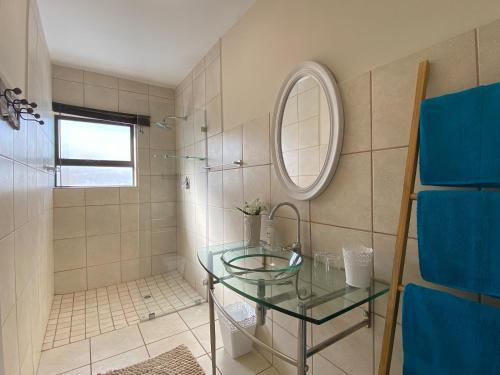 a bathroom with a glass table and a mirror at Blue Star Villa in Tergniet