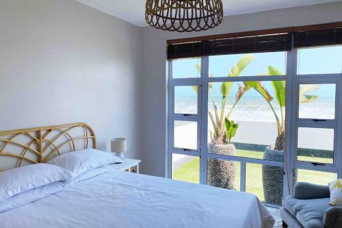 - une chambre avec un lit et une vue sur l'océan dans l'établissement On The Beach No 04, à Swakopmund